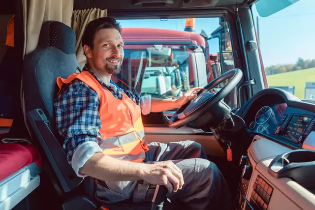 A smiling truck driver beside a truck